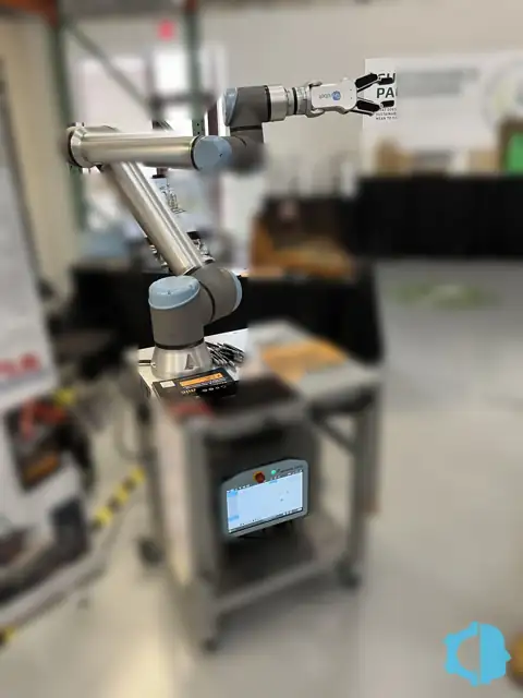 Universal Robots UR10e collaborative robot with a two-finger gripper on a mobile stand with its teach pendant